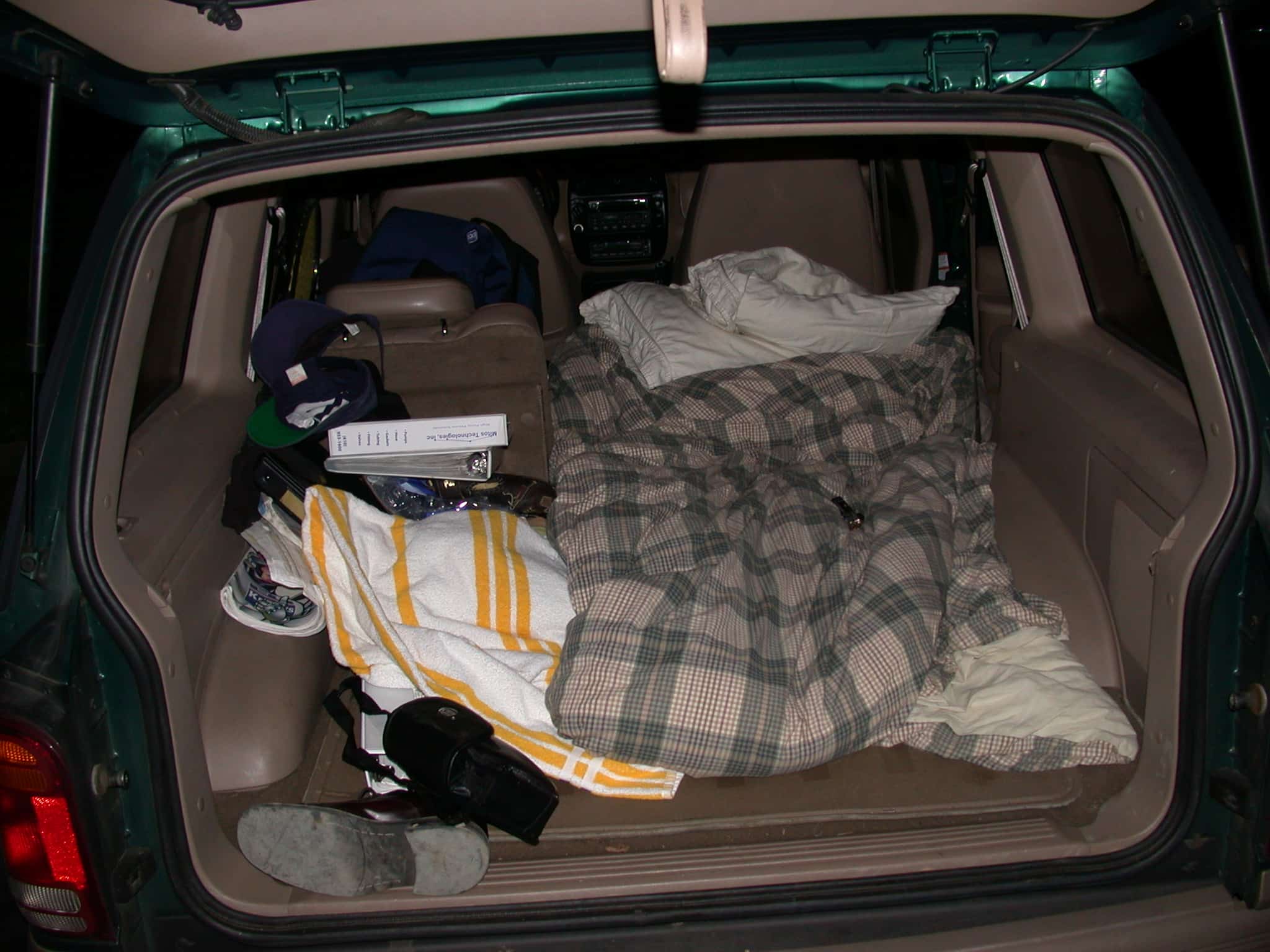 Bedding laid out in the back of a car