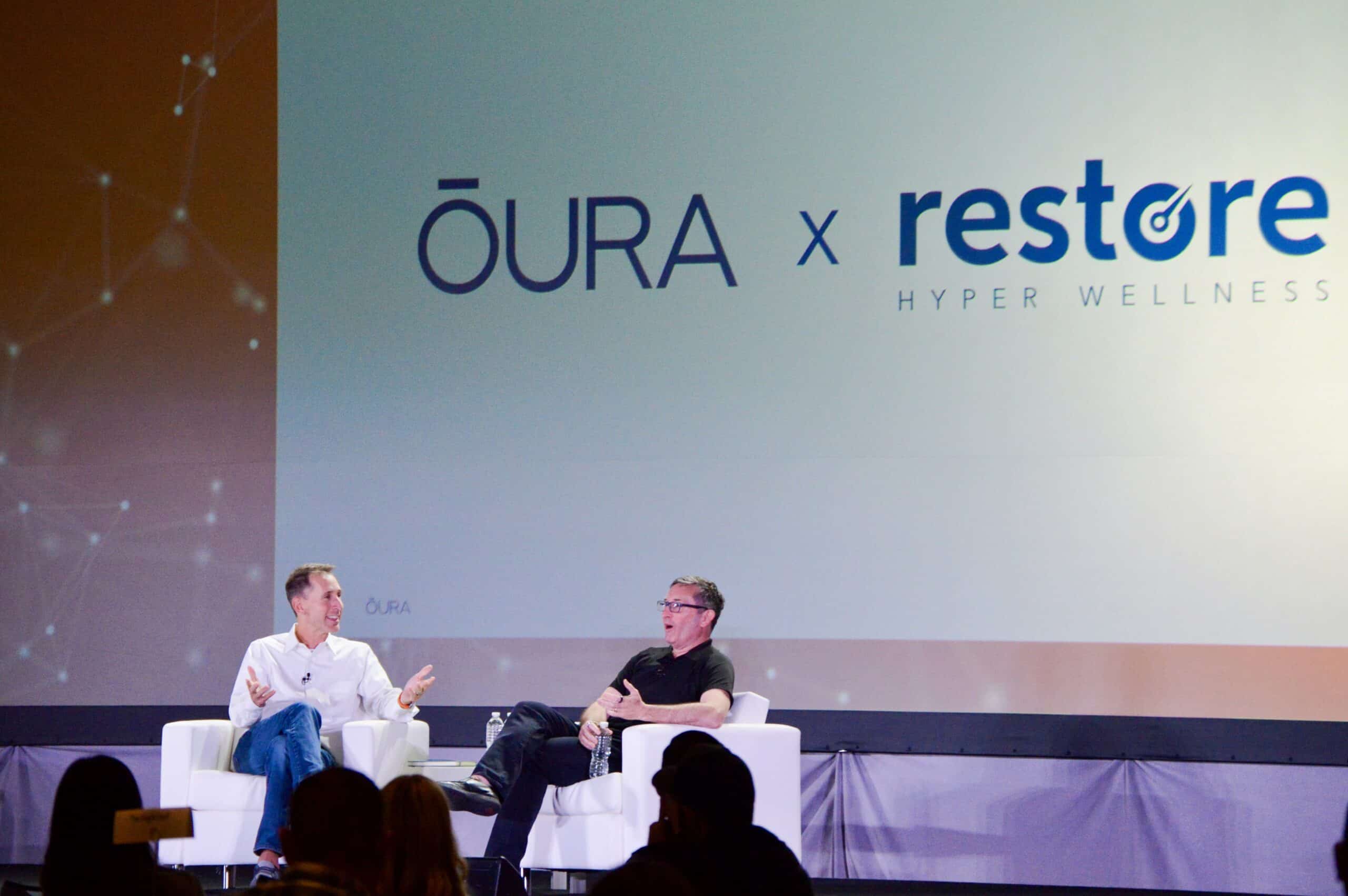 An on-stage session under an ŌURA and Restore Hyper Wellness banner