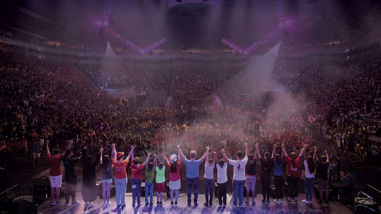 Students on stage in a packed arena