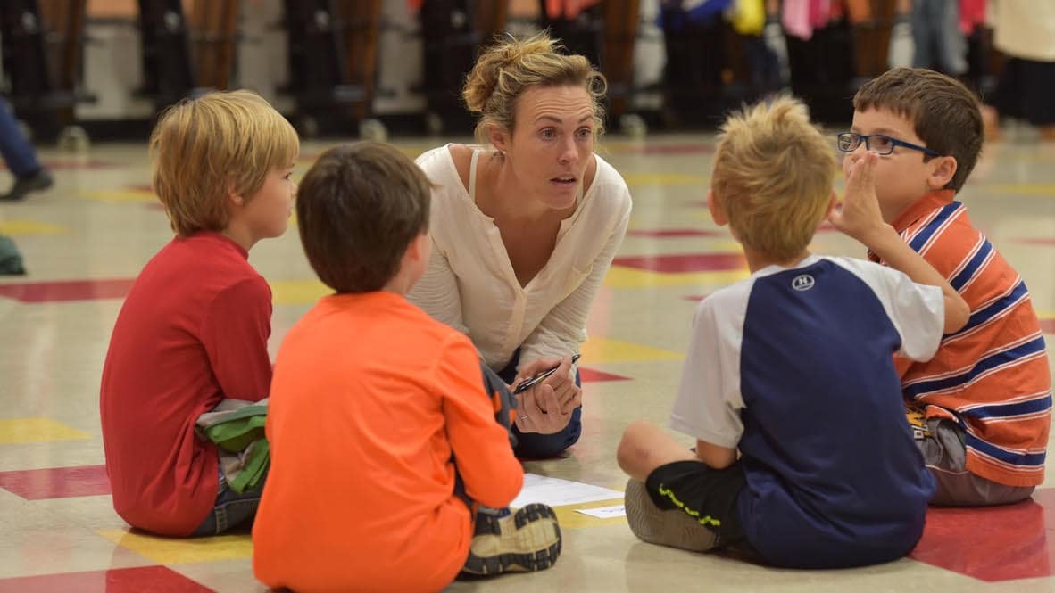 Nicole Welch leading a group of young children in a classroom