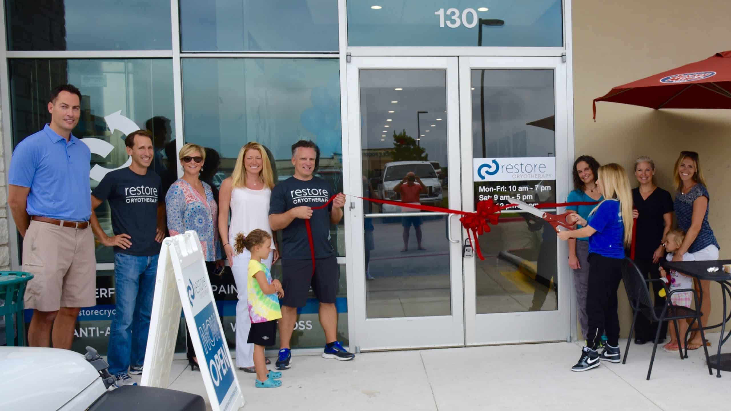 A ribbon-cutting outside an early Restore Hyper Wellness studio